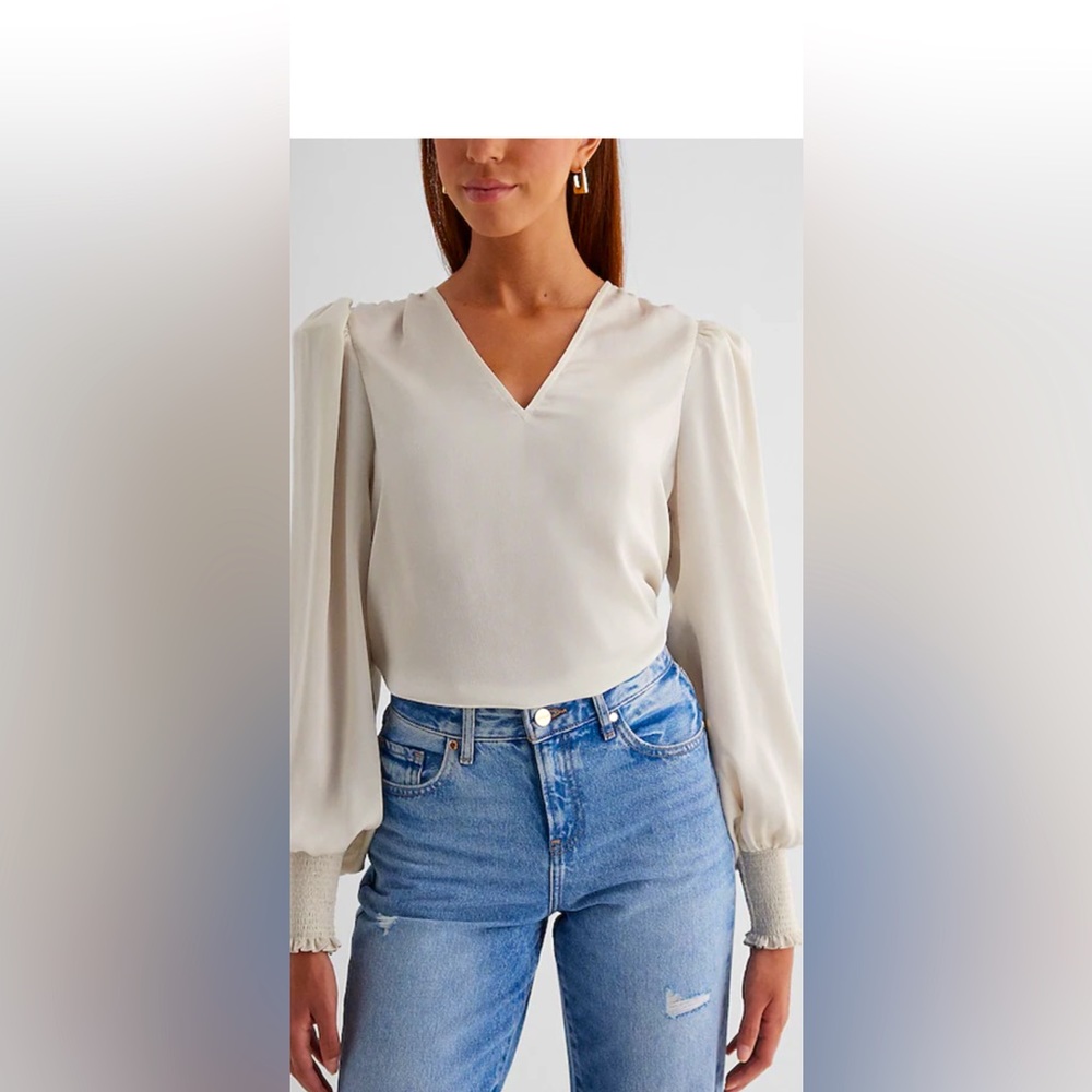 White professional Express top with ruched detailing on the wrists.